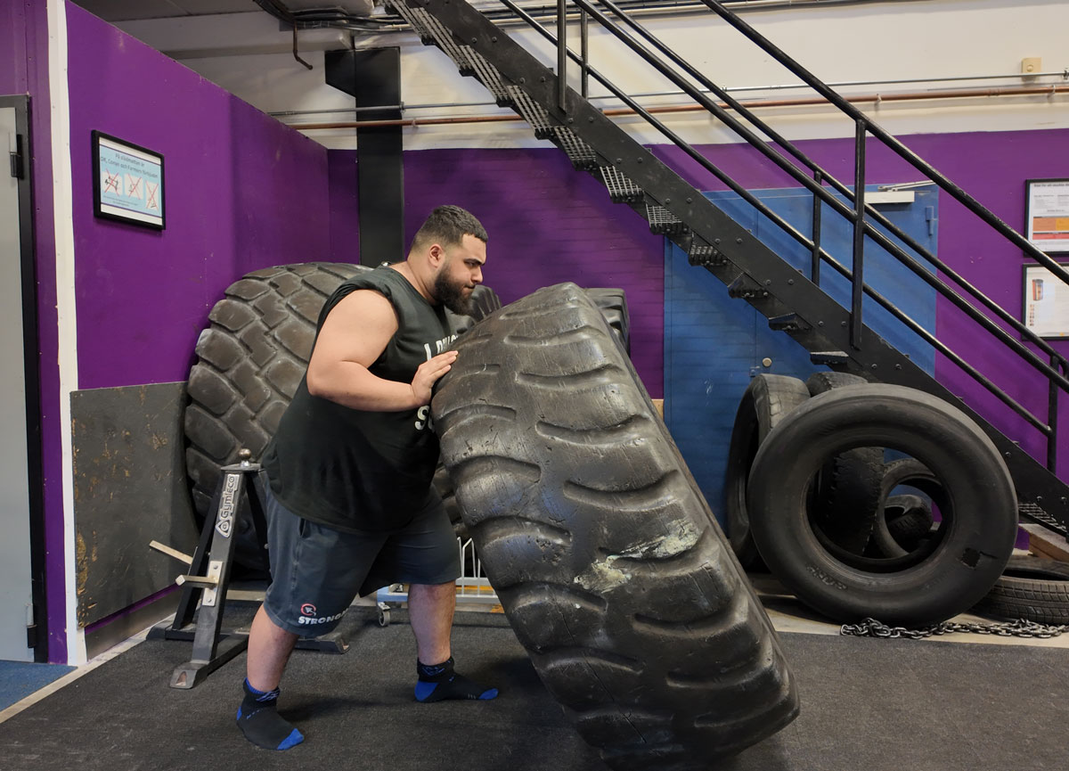 Coach is training with workout big tire.